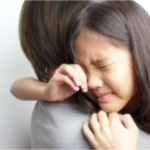 泣いている娘を抱く母親