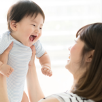 赤ちゃんを抱き上げる母親