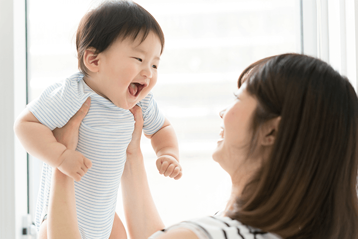 赤ちゃんを抱き上げる母親